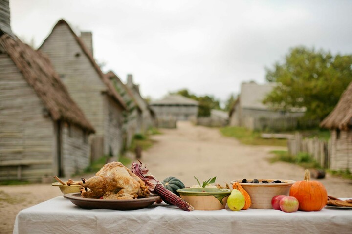 Thanksgiving food including a cooked turkey and vegetables lined up on an outdoor table at Plimoth Patuxet.